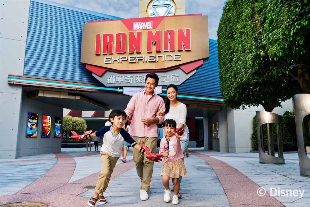 A family standing in front of an Iron Man attraction