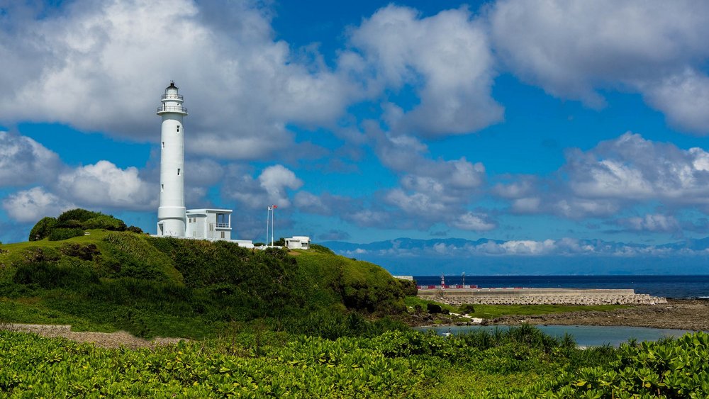 Lighthouse overlooking the ocean on a green island