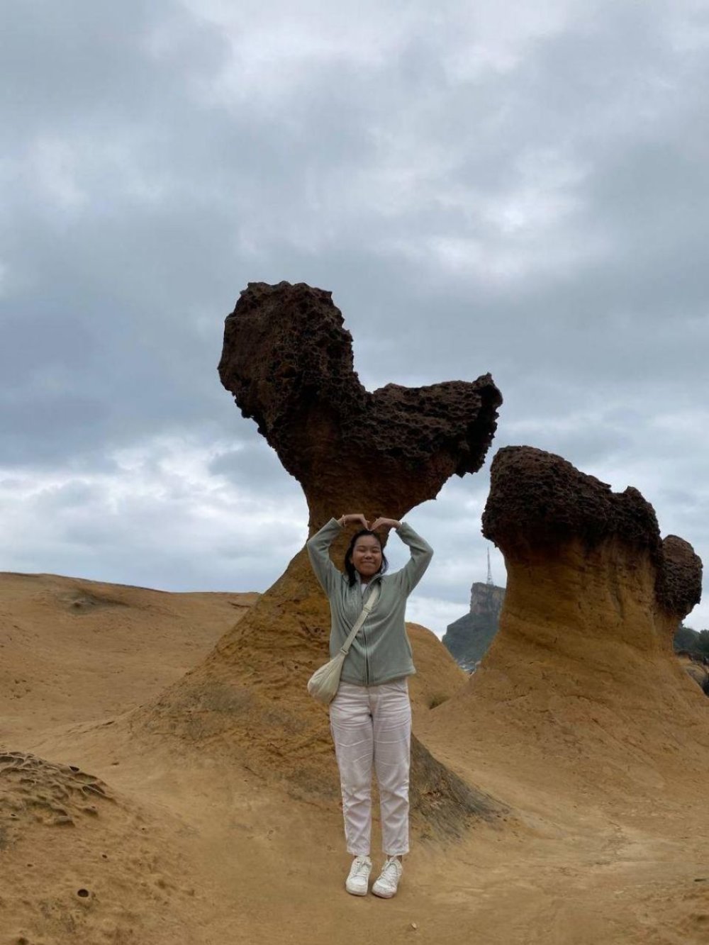 Girl standing in front of a heart shaped rock