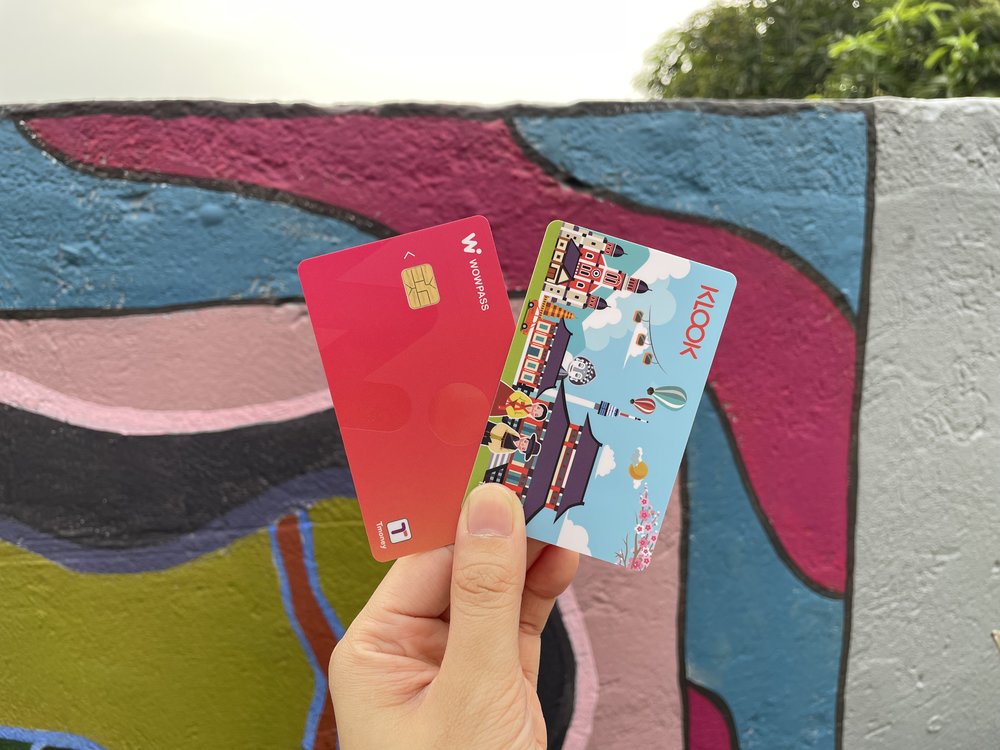 a hand holding up korea's wowpass card and t money card