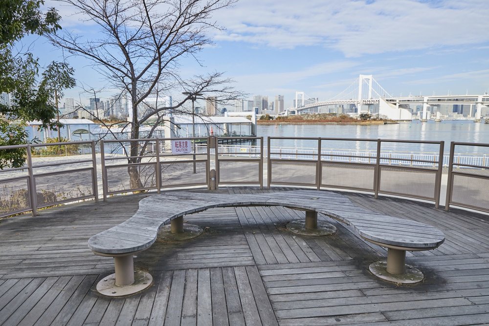 a bench overlooking tokyo bay and rainbow bridge