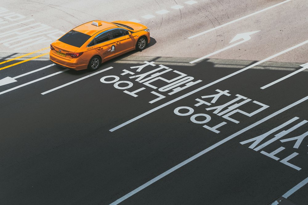 a yellow taxi in a wide road in korea