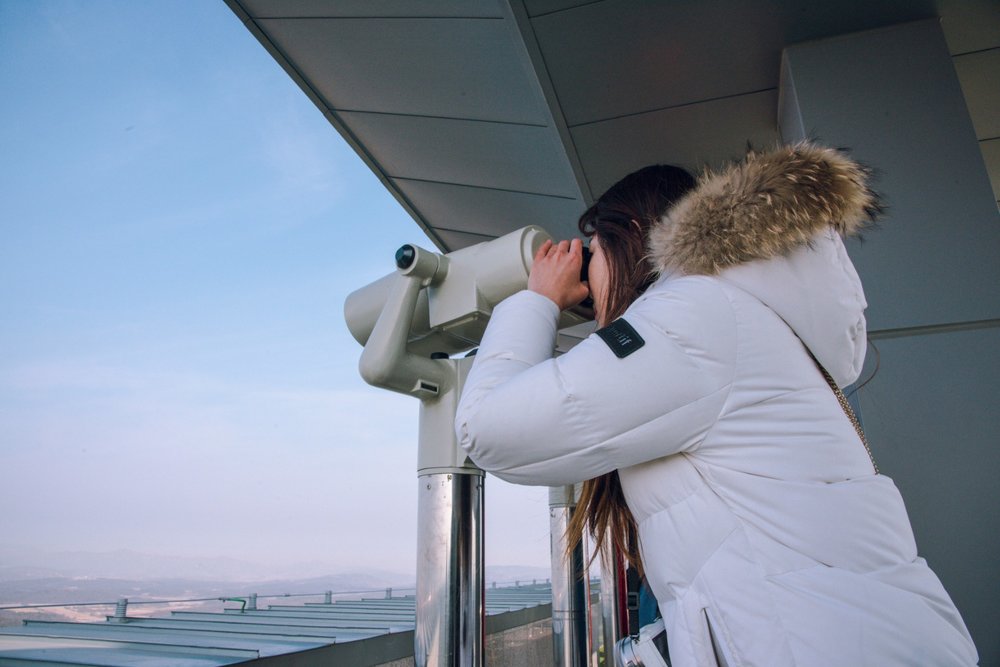 a woman looking through the binoculars in DMZ