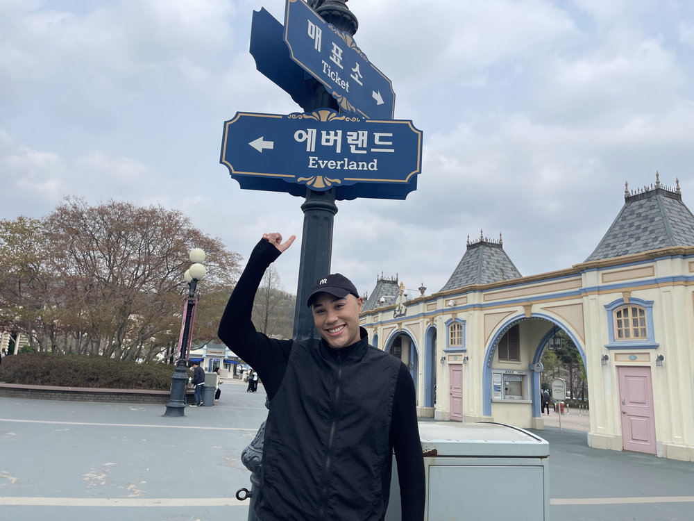 person pointing at the Everland street sign in korea everland theme park