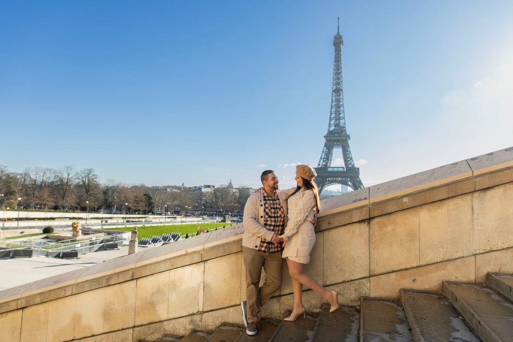 a couple posing with the eiffel tower in the background