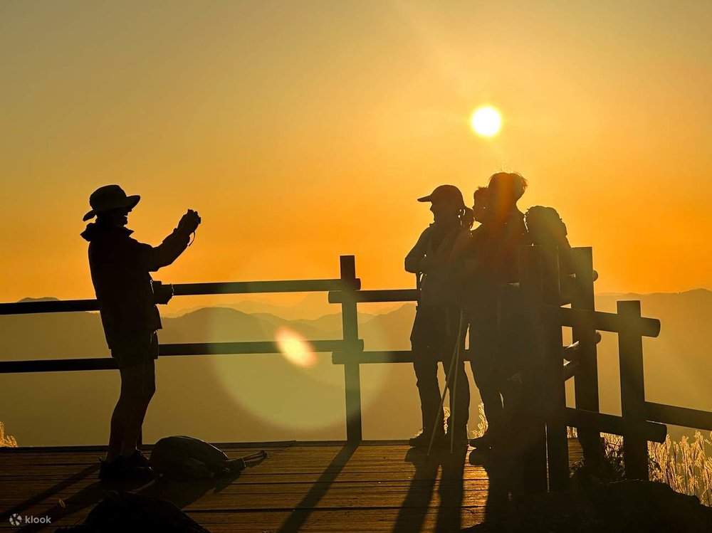 hikers taking a photo with the sunset