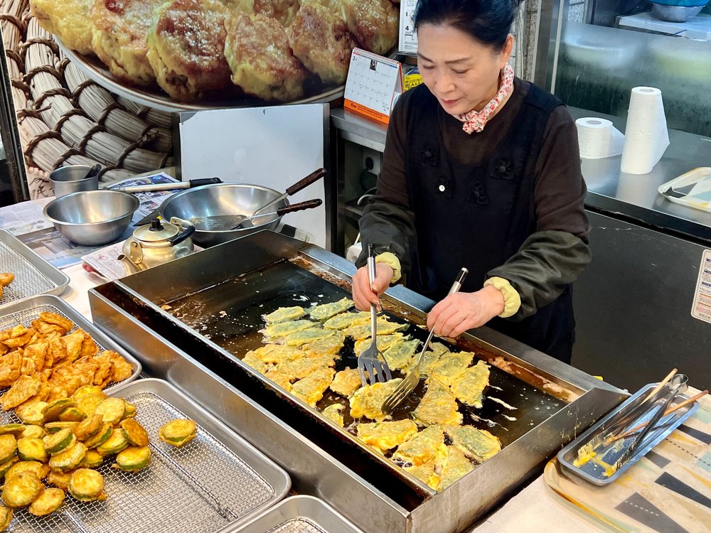 lady cooking in a food stall in korea