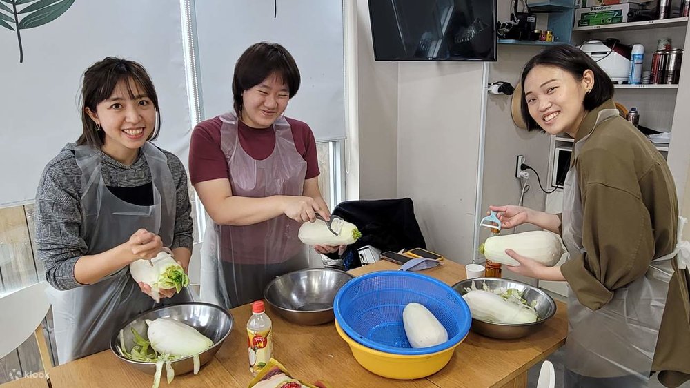 people learning how to make kimchi