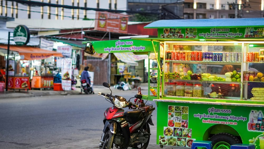 A cart of fruit and beverages