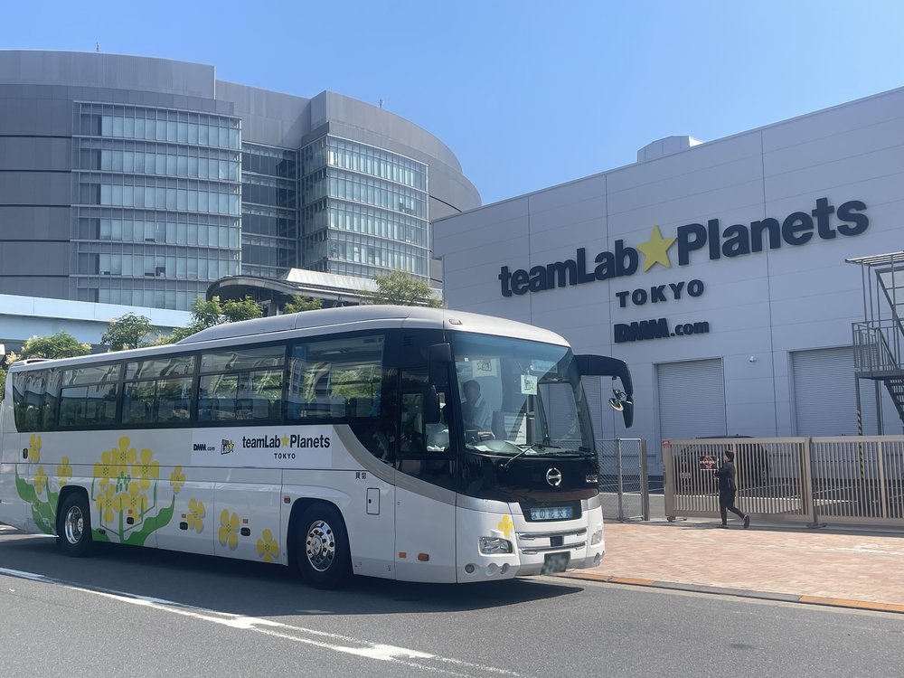 a direct bus going to teamlab planets tokyo parked in front of the facility