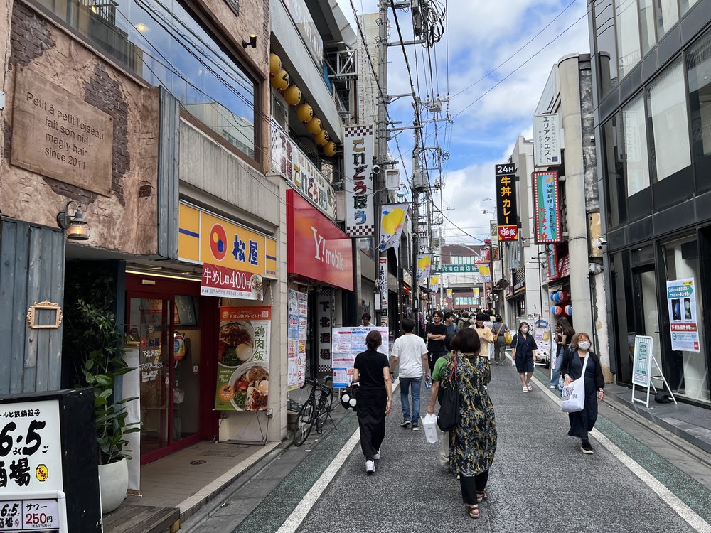 street lined with coffee shops and signage in shimokitazawa