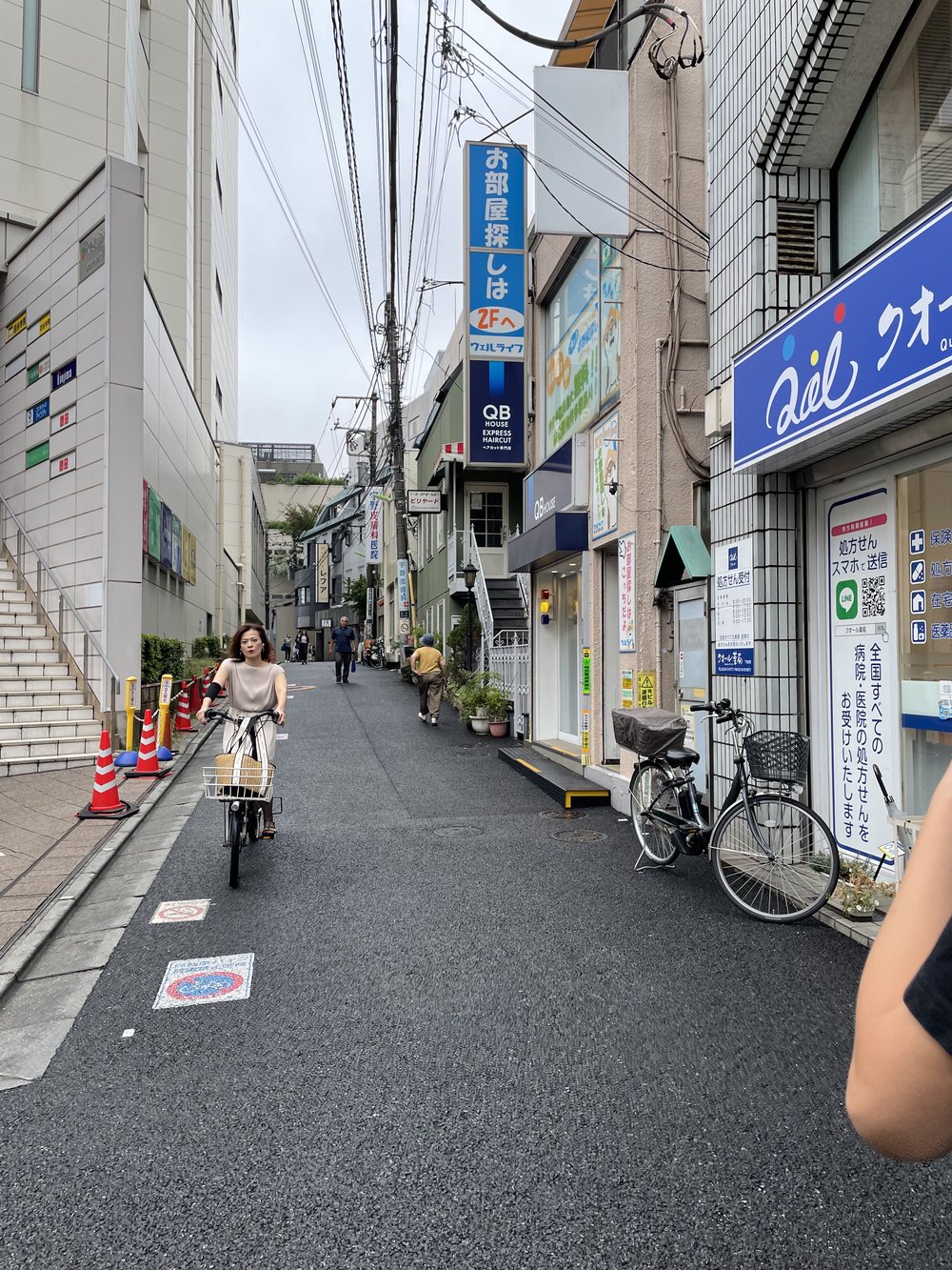 lady riding a bicycle in a street in shimokitazawa
