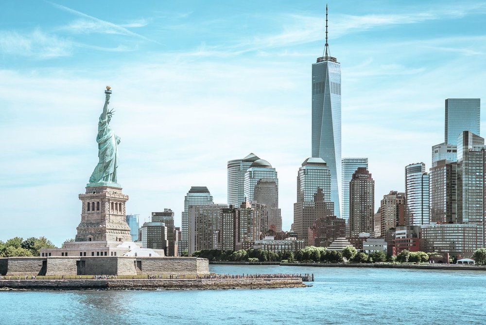 a photo of the statue of liberty and the manhattan skyline including One World Trade Center