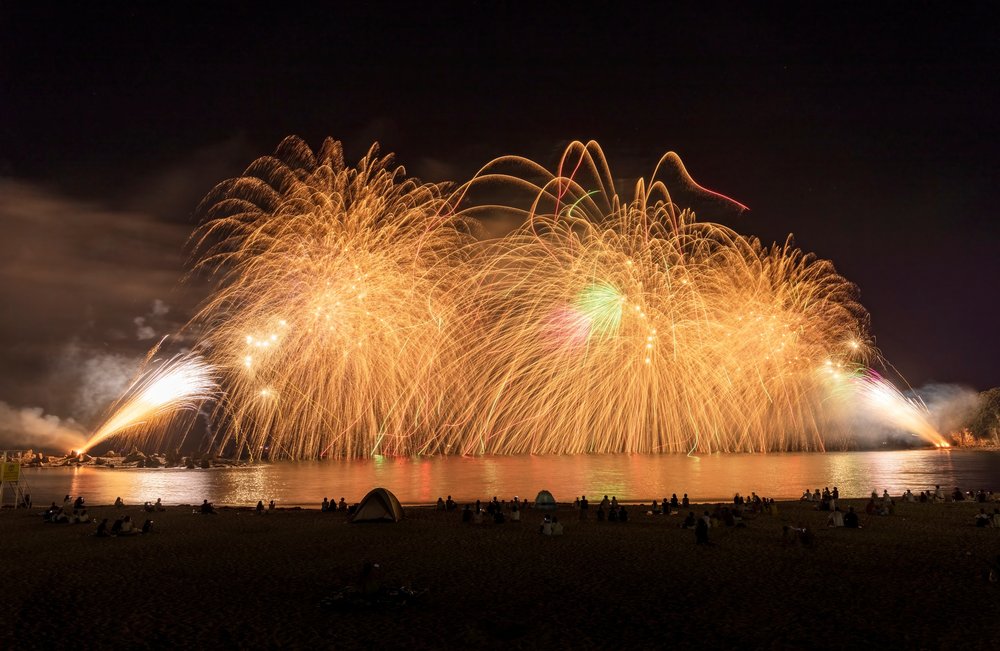 Shirahama beach fireworks display with people camping
