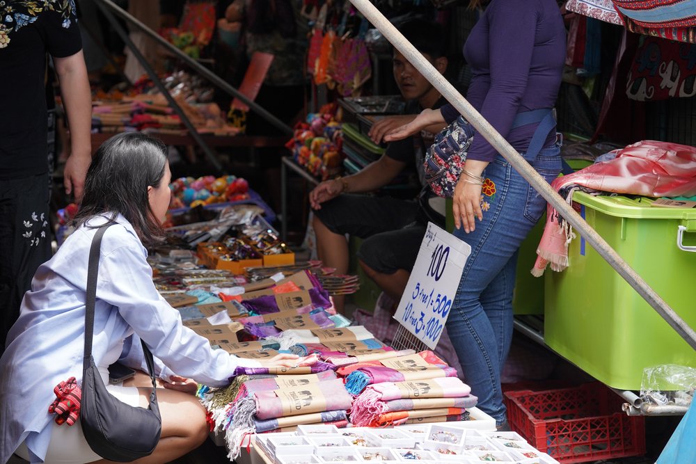 girl looking at merchandise at floating market