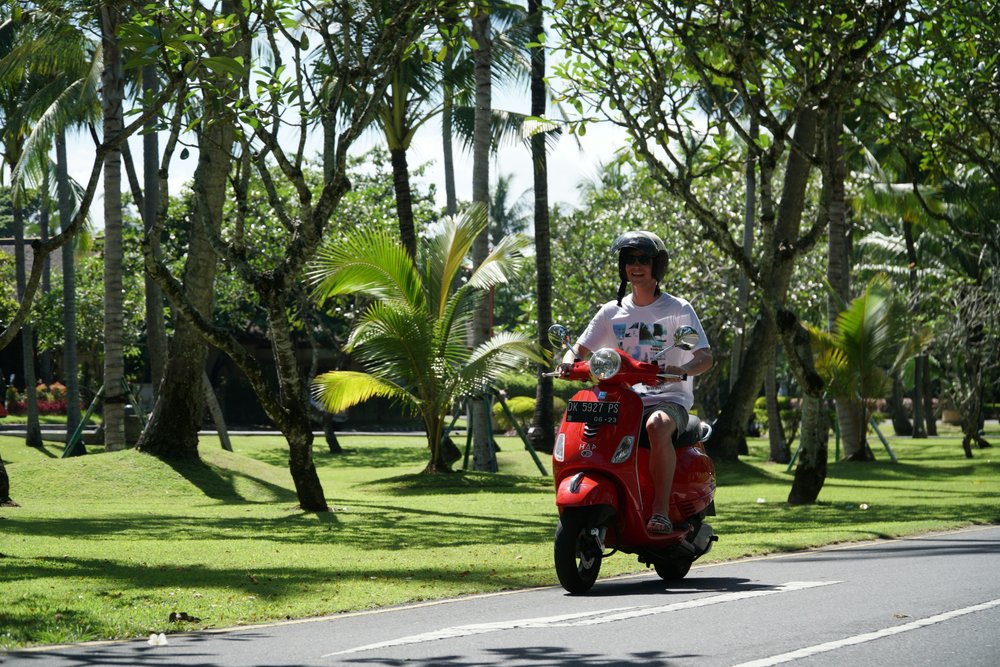 sanur bali - man riding motorbike scooter