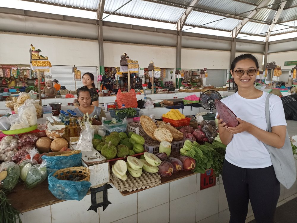 sanur bali - girl buying fruits in market