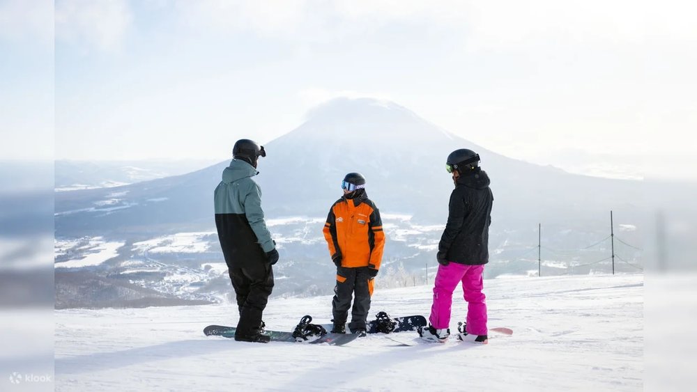 three people on top of mountain with snow