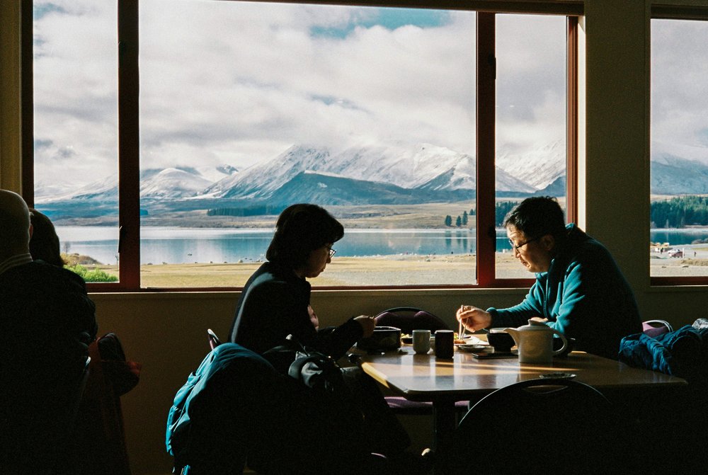 New Zealand South Island Road Trip Itinerary - Travelers dining in a restaurant in front of Lake Tekapo