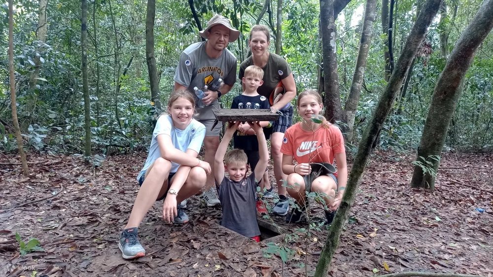 Kids taking photos in one of the underground tunnels in Cu Chi Tunnels