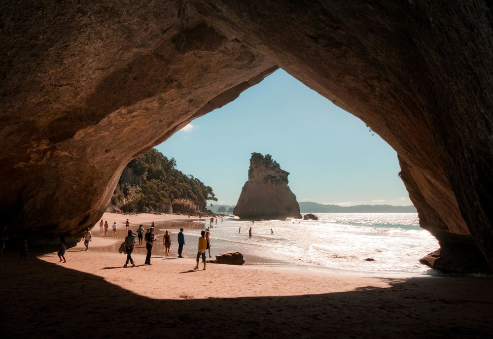 Cathedral Cove - people walking in hot water beach beside cathedral cove