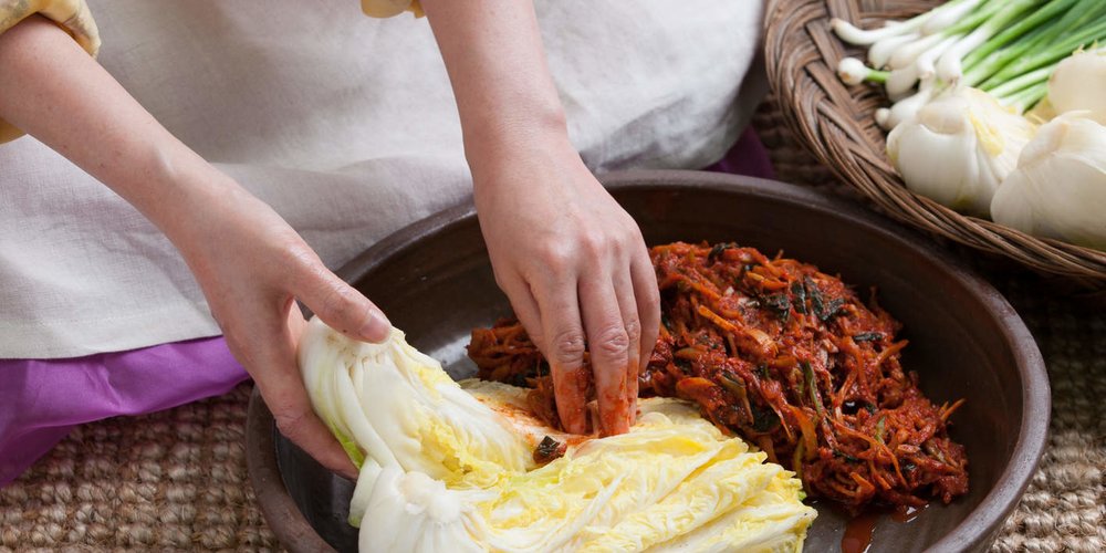 how to make kimchi - person making kimchi from scratch