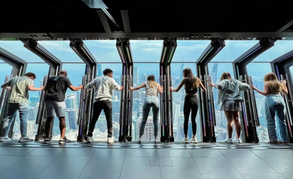 A line of people looking down from an observatory deck