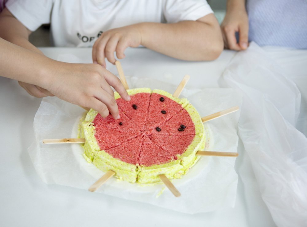 hand reaching out to watermelon popsicles
