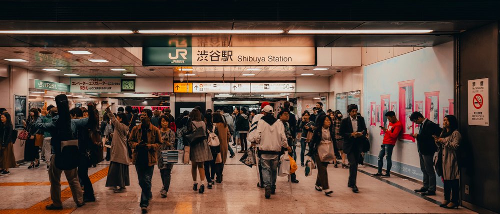 crowds of people entering and exiting Shibuya Station in Japan