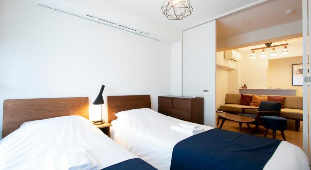 two beds with white bedsheets