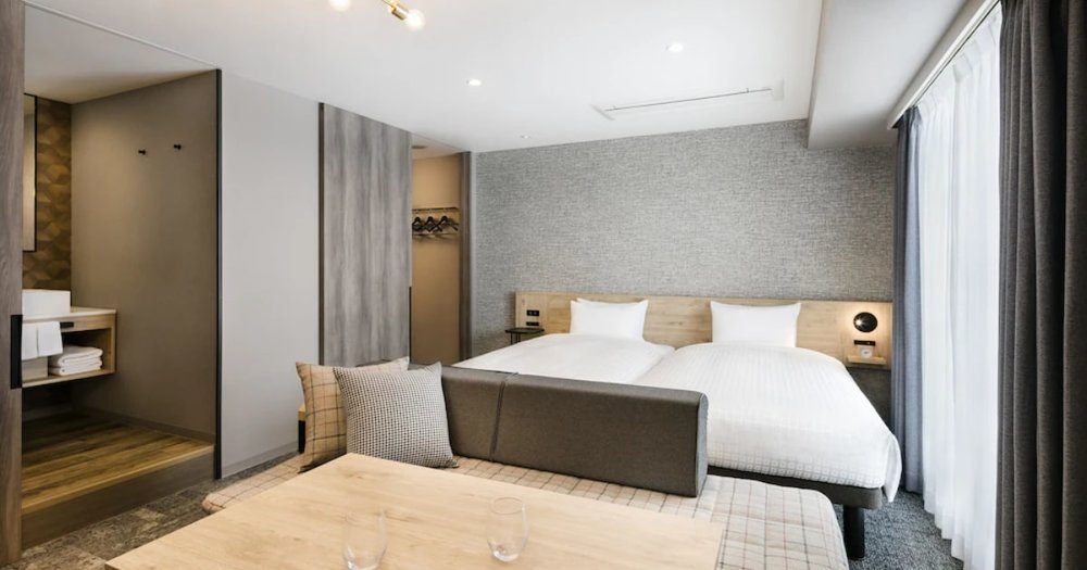 modern hotel room with grey walls and white beds