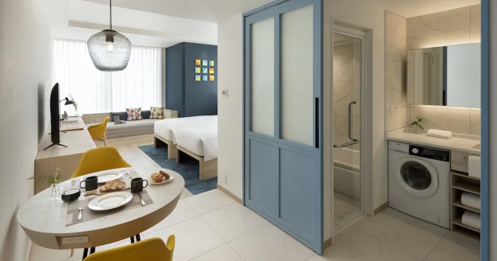 hotel room interior with washing machine and round dining table