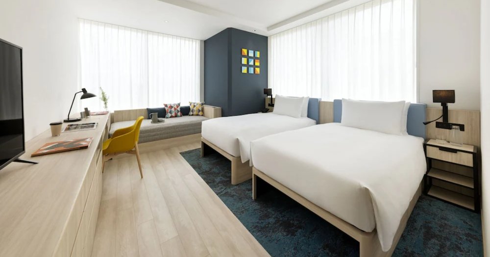 two beds in a spacious hotel bedroom