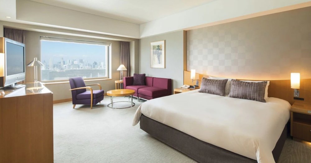 spacious bedroom interior with bed with white and purple sheets