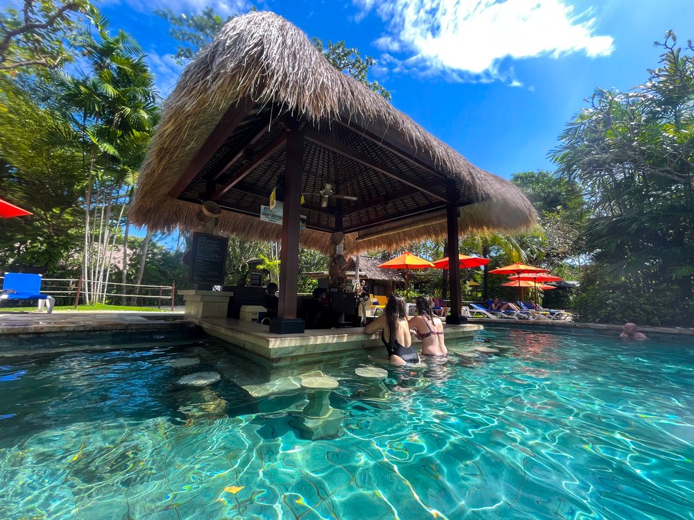 a tropical hut in the middle of a swimming pool