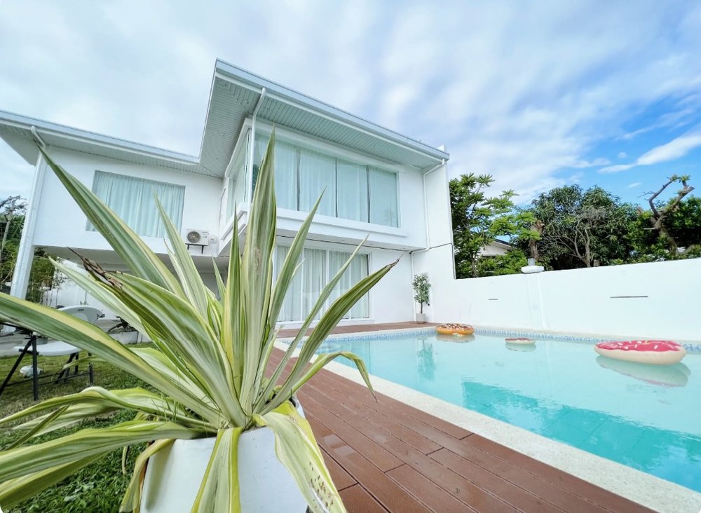 Swimming pool beside a white house