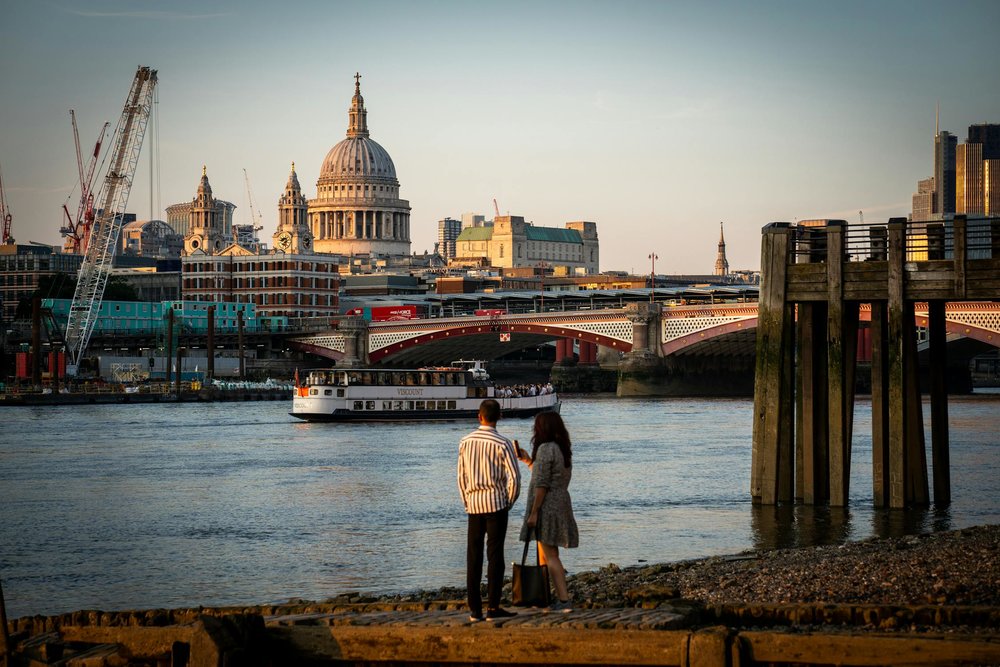 Couple standing near thames with Saint Pauls Cathedral