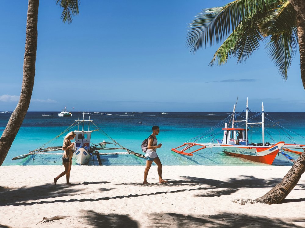 Tourists walking in the white sand beach