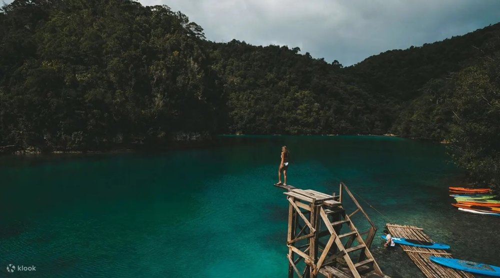 Girl taking a high dive in the emerald green waters