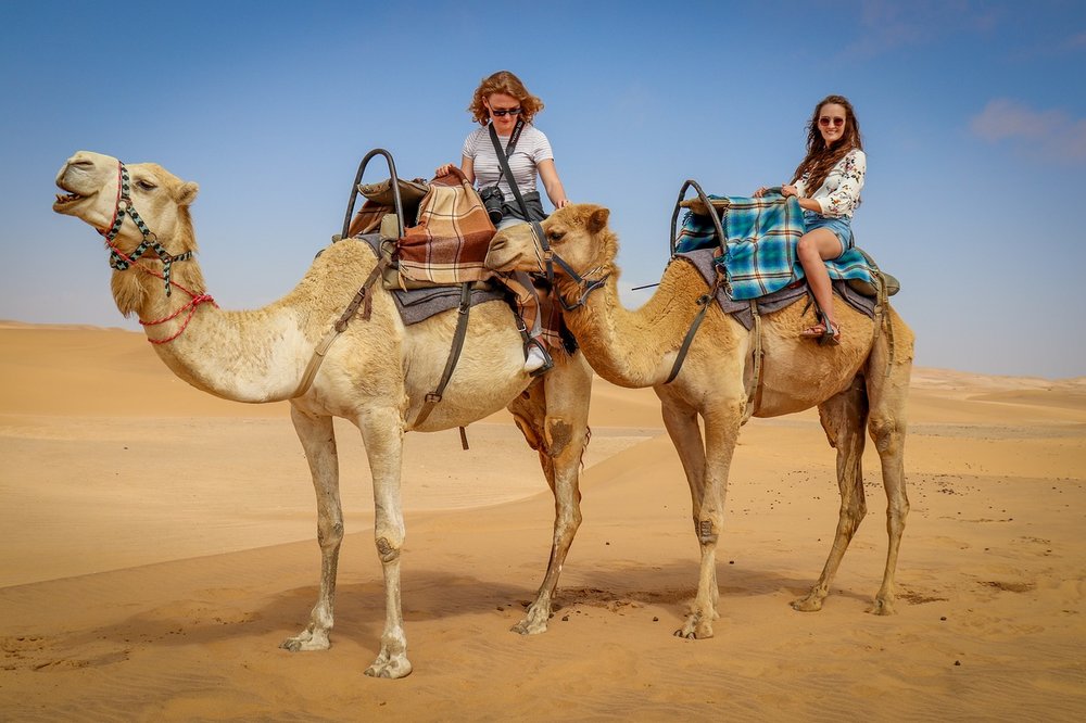 Two girls riding a camel