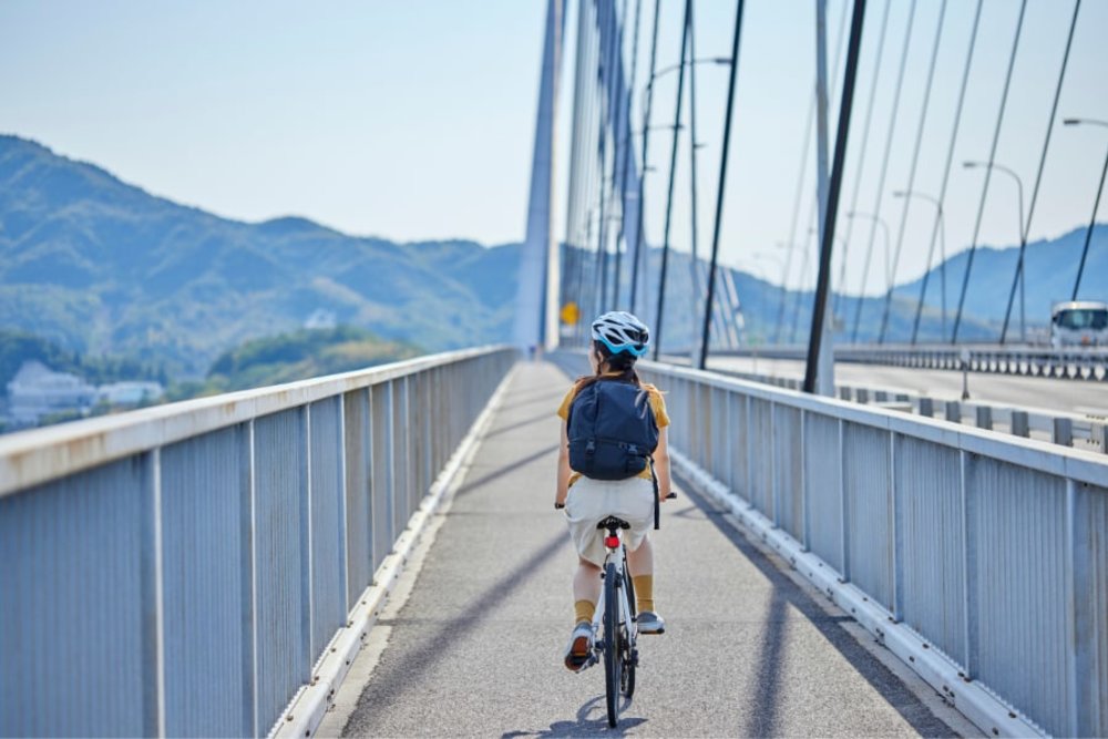 shimanami kaido - person cycling over a bridge