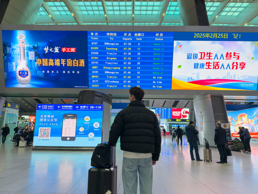 Beijing to Shanghai High Speed Rail - Traveler at Beijing South Station looking at Train Timings