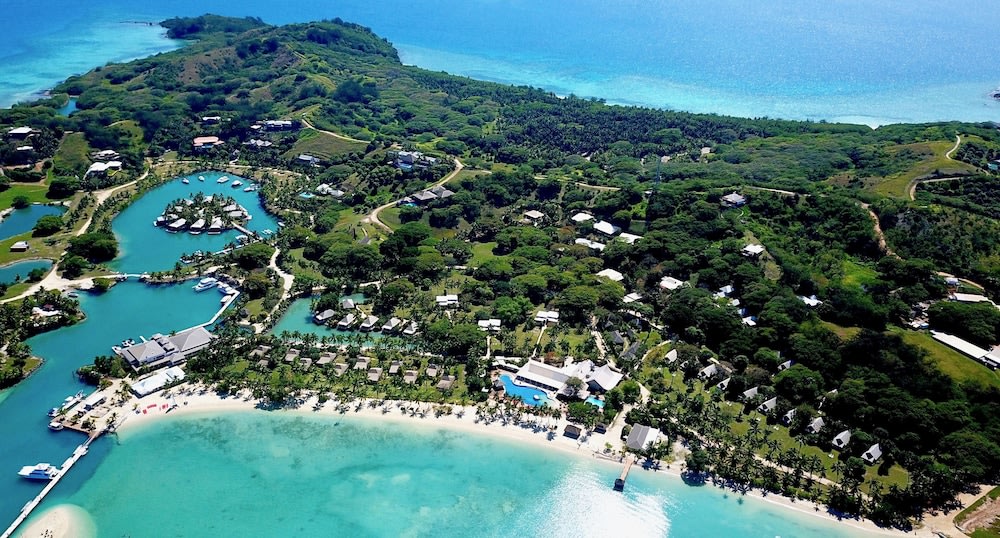 fiji bungalows over the water - aerial view of island 