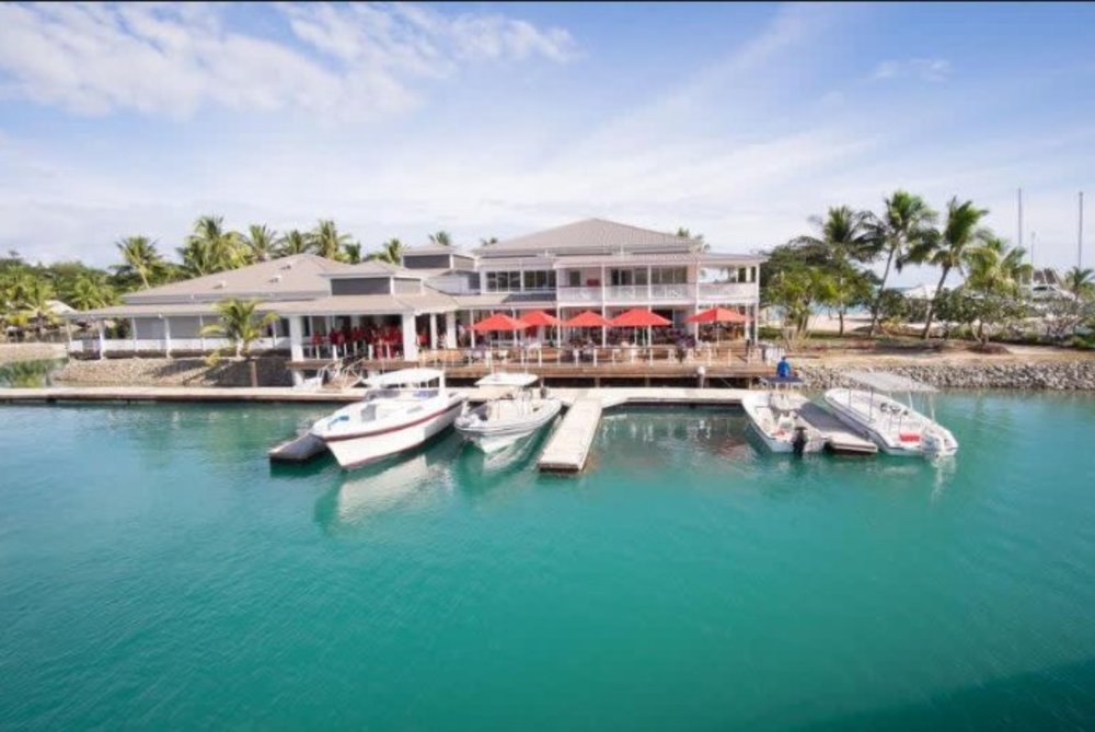 fiji bungalows over the water - ocean with boats
