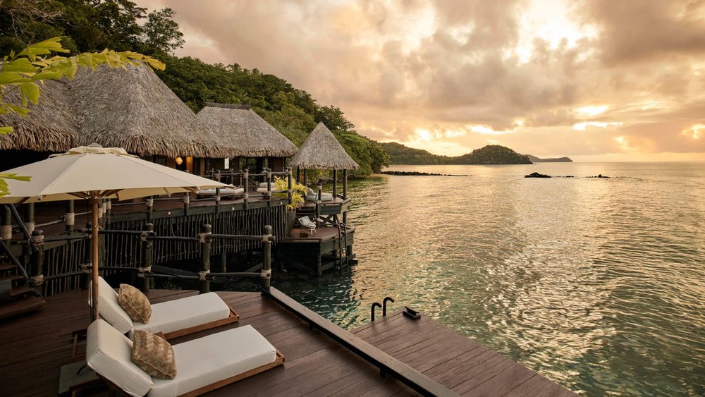 fiji bungalows over the water - island at sunset