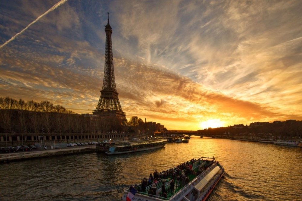 paris at night - seine river at sunset with boat and eiffel tower