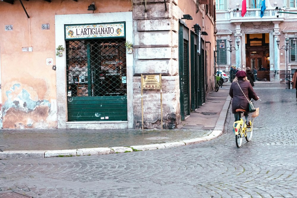 [Bike Rental in Rome] Woman biking on a street in Rome