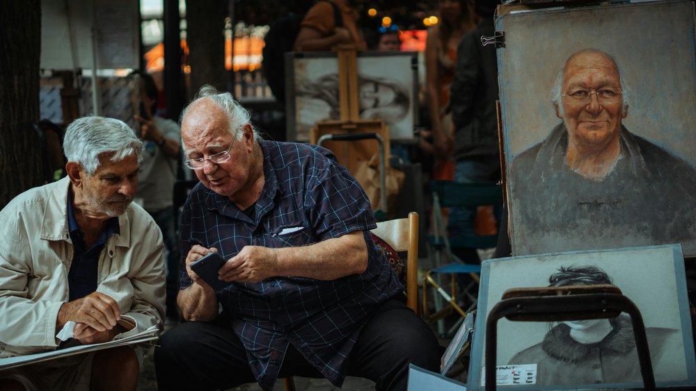 two people looking over a phone