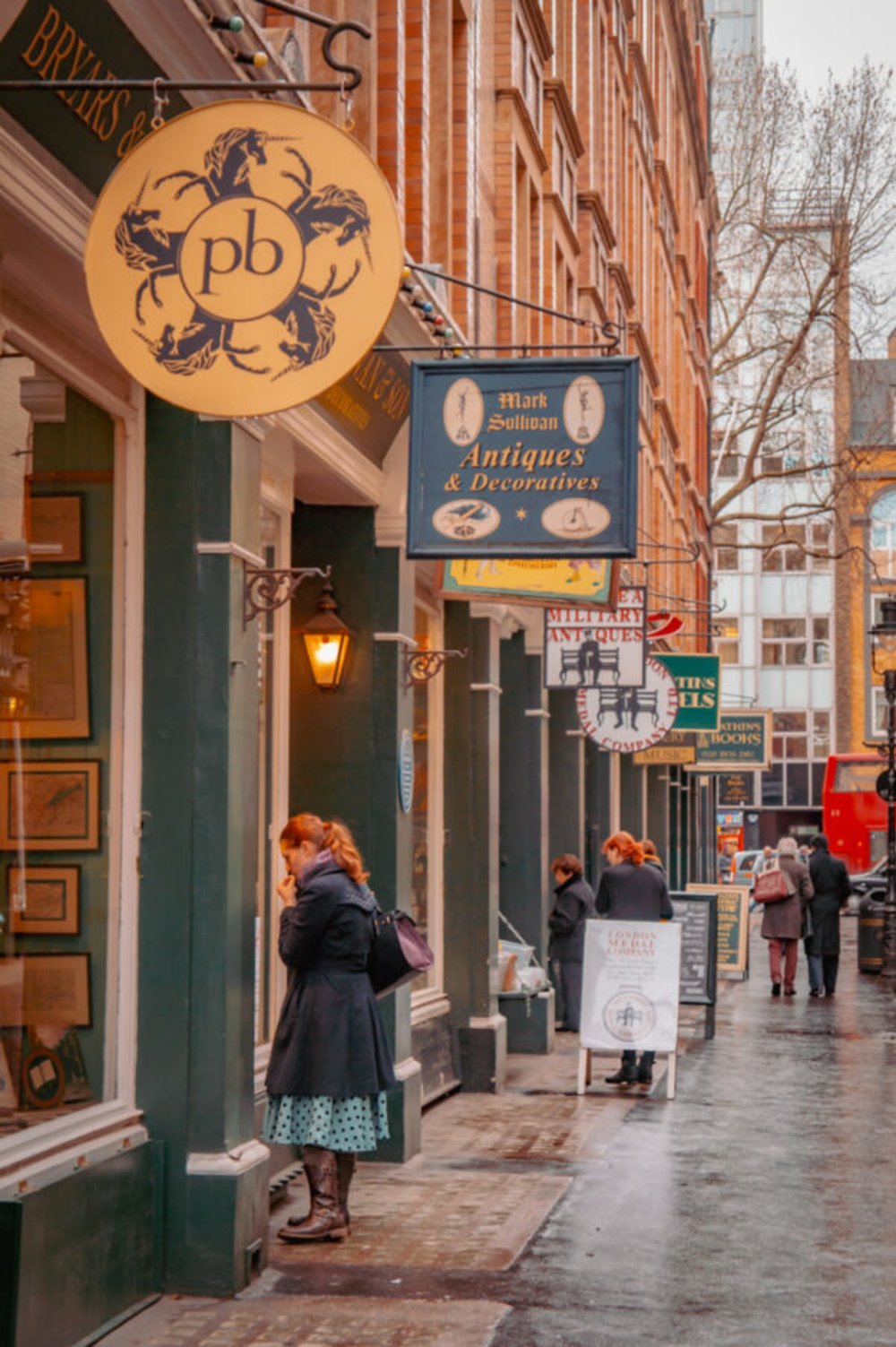  People browsing shop windows along Cecil Court in London