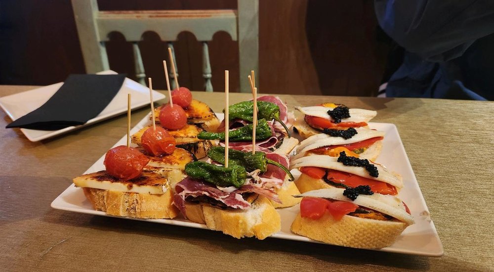 Assorted tapas in Barcelona with peppers, ham, cheese, and caviar on bread